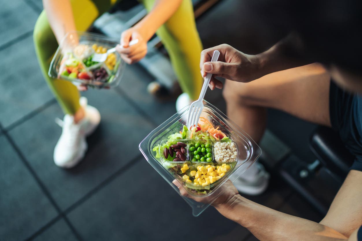 Shot of a man and woman eating a healthy vegan meal at the gym