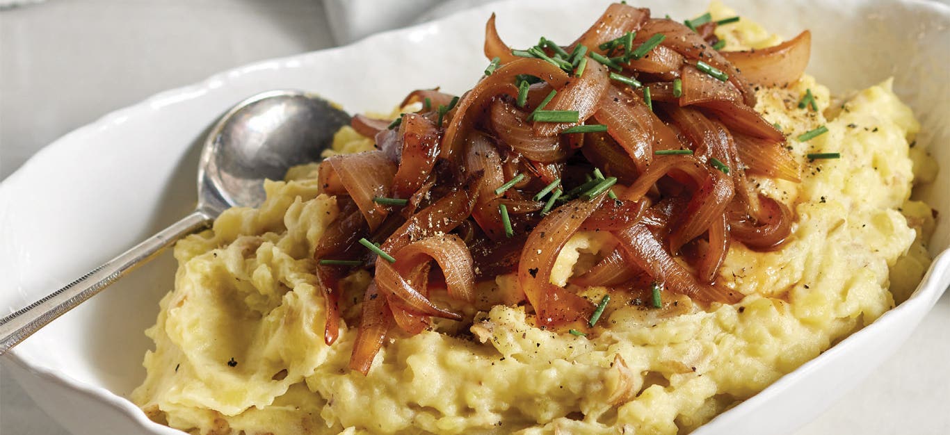 Caramelized Onion Mashed Potatoes in a white ceramic serving dish