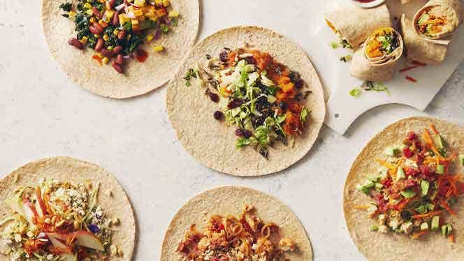 five variations of a vegan breakfast burritos against a white countertop