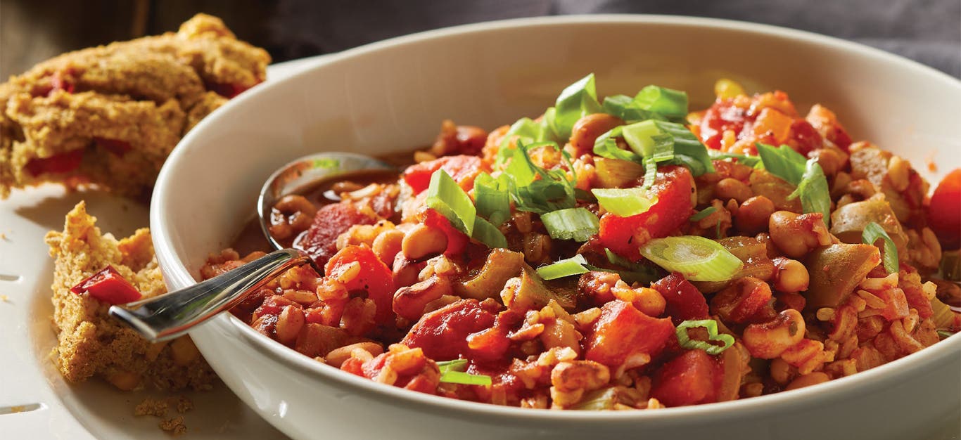 Veggie Jambalaya with Black-Eyed Peas in a whitw ceramic bowl with a side of cornbread