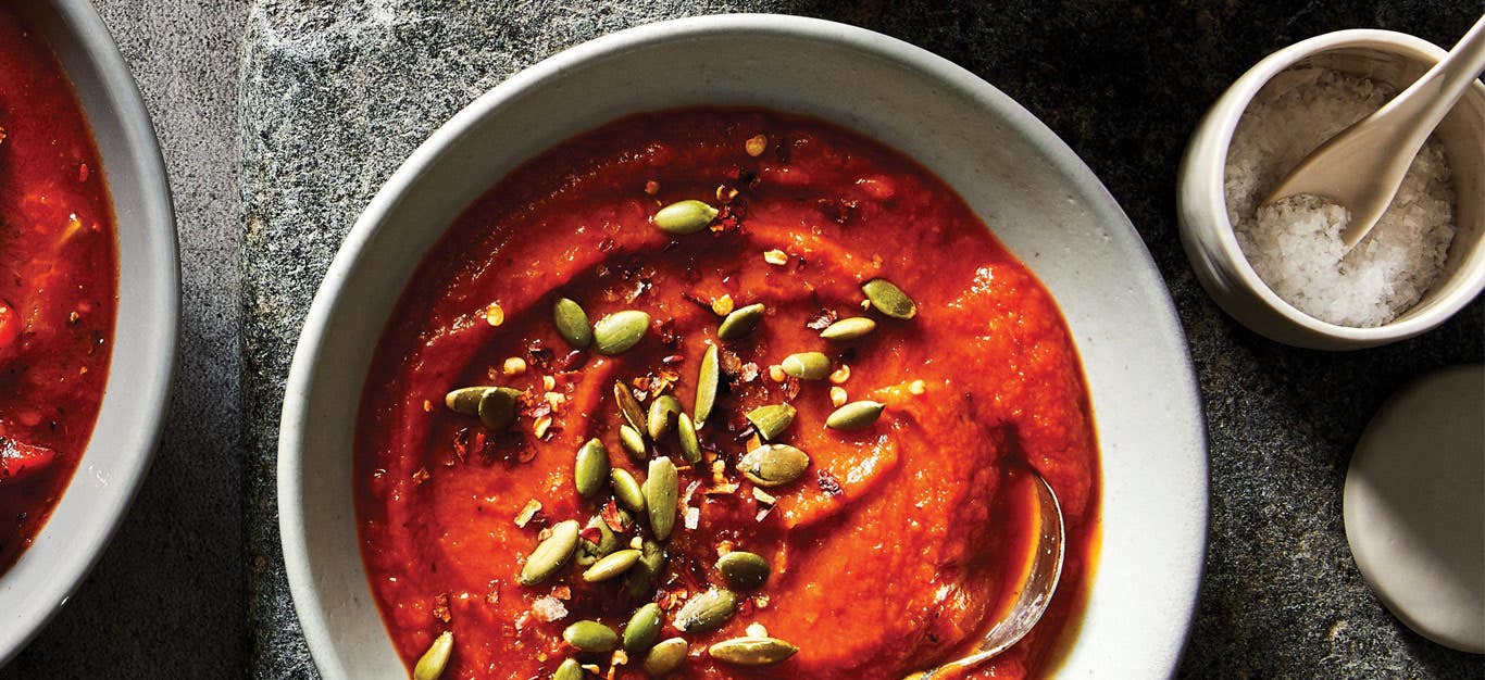 Curried Sweet Potato Soup topped with pumpkin seeds in a white ceramic bowl