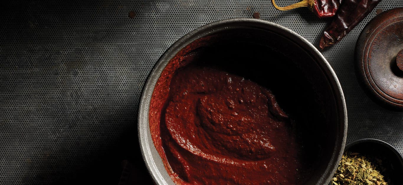 Easy Mole Sauce in a gray ceramic bowl against a dark gray background