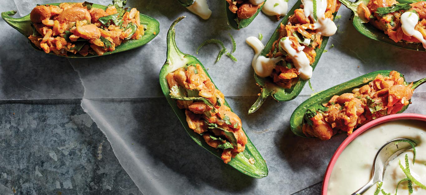 Vegan Stuffed Jalapeños with Lime Crema against a dark gray countertop