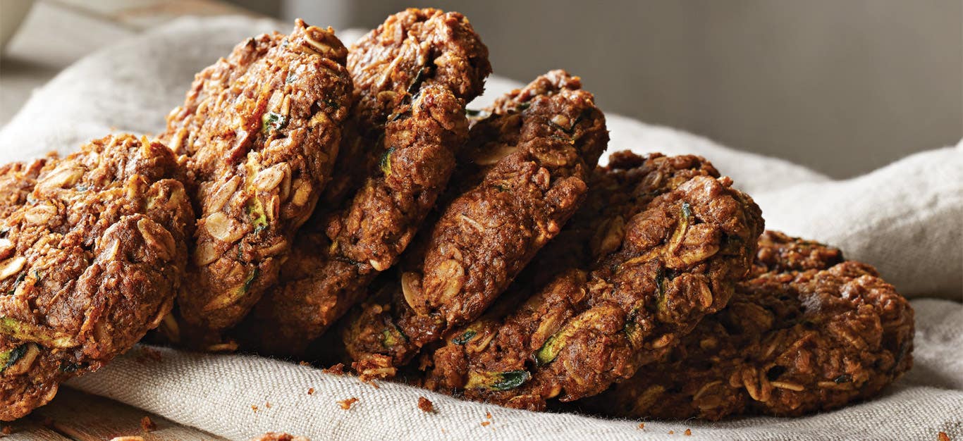 Dreamy Zucchini Breakfast Cookies stacked in a row on a white kitchen towel