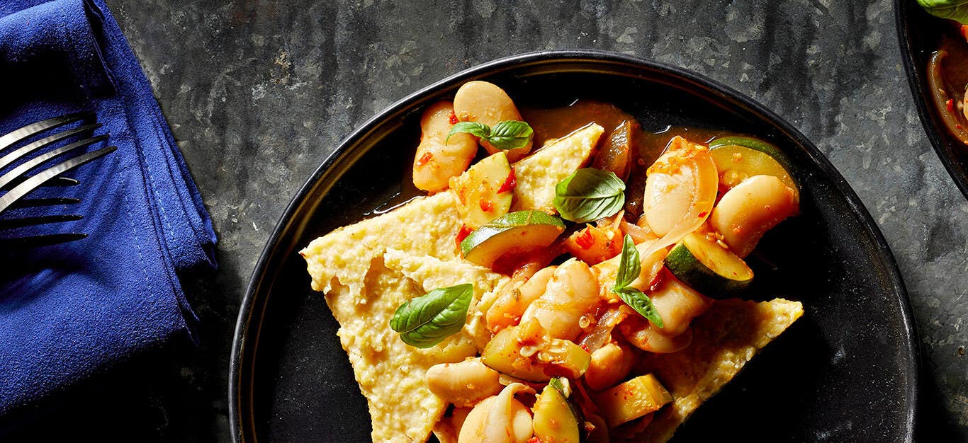 Calabrian Chile Beans and Polenta in a dark grey ceramic bowl