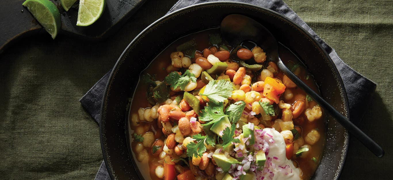 Pinto Bean and Hominy Soup in a black ceramic bowl