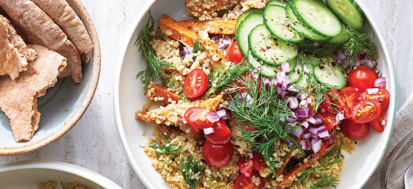 Shawarma Sweet Potato-Quinoa Bowl in a white ceramic bowl with a side of pita bread