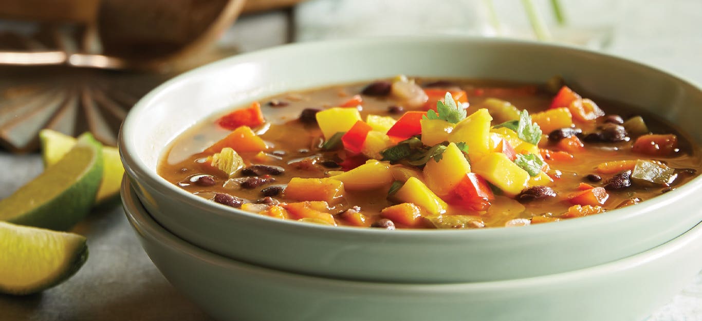 Jerk Black Bean Soup with Mango Salsa in a light green ceramic bowl