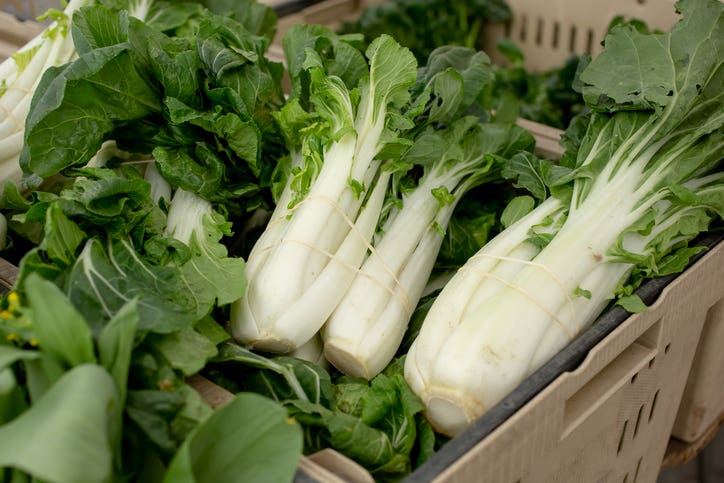 full-size bok choy in a bin at a farmers market