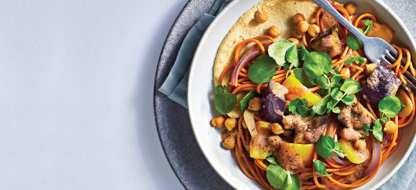 Lebanese 7-Spice Noodle Bowl with Eggplant and Roasted Garlic in a white bowl on a pale grey background