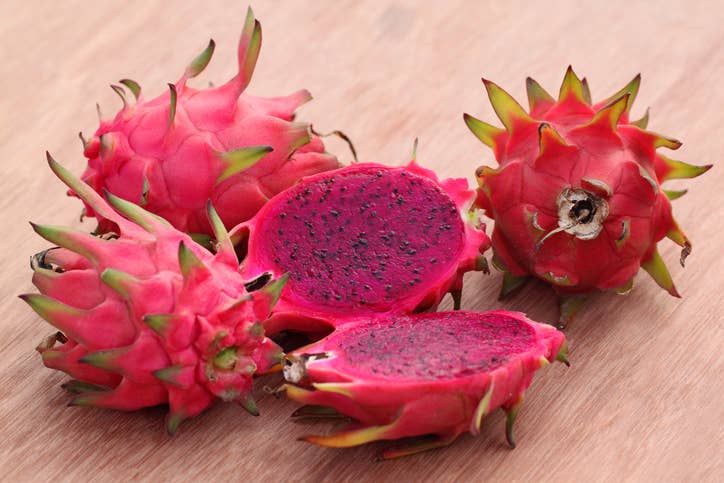Red dragon fruit cut open to reveal fuchsia interior flesh