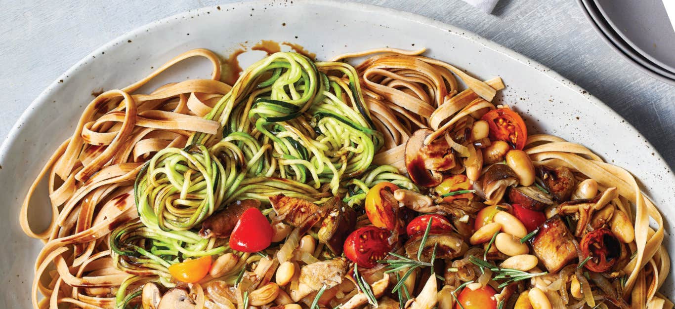 Whole Grain Fettuccine with Zoodles and Balsamic-Glazed Vegetables in a white ceramic bowl against a pale grey background