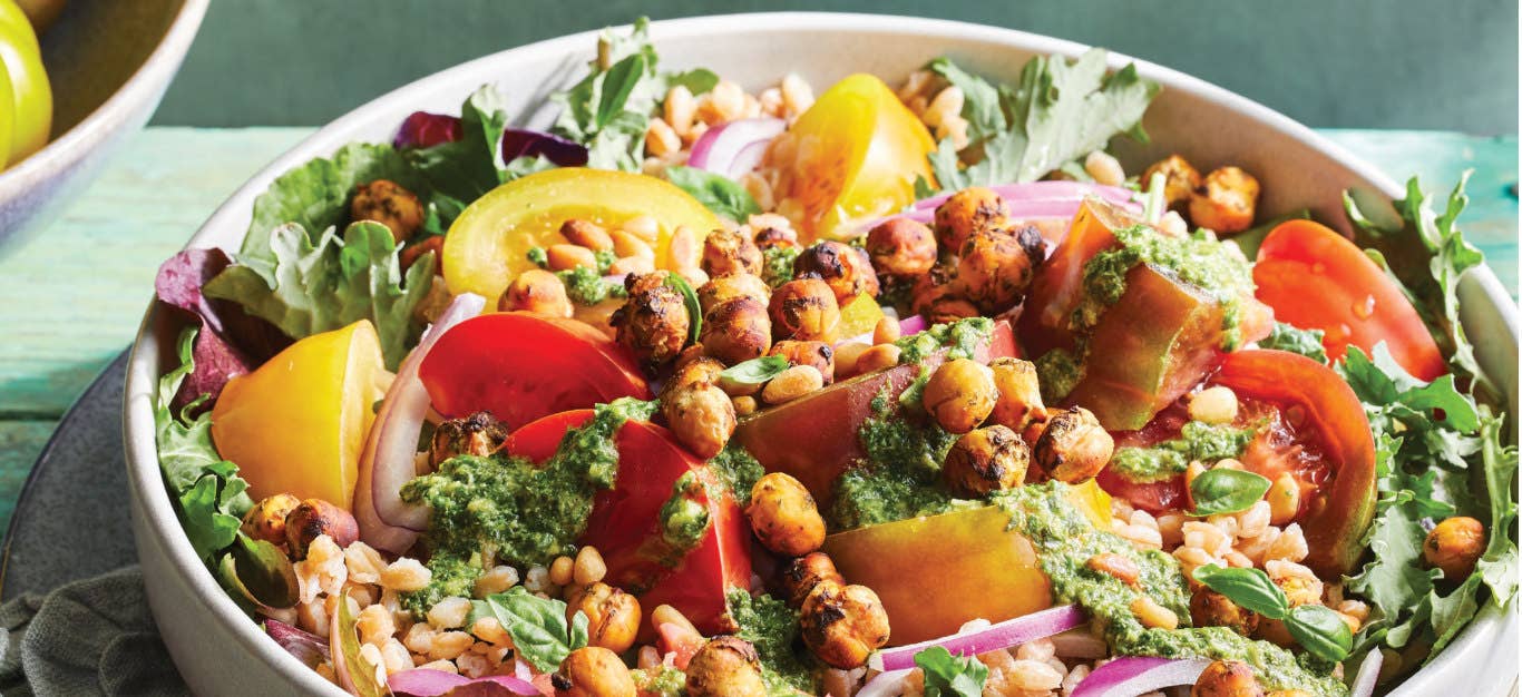 Hearty Pesto Salad with Tomatoes, Farro, and Air-Fried Chickpeas in a large white bowl