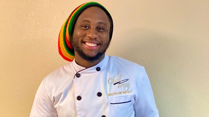 Ital chef Troy Levy wears a Rasta cap and a white chef's coat