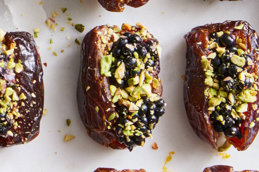 three Medjool dates stuffed with blackberries and sprinkled with pistachios