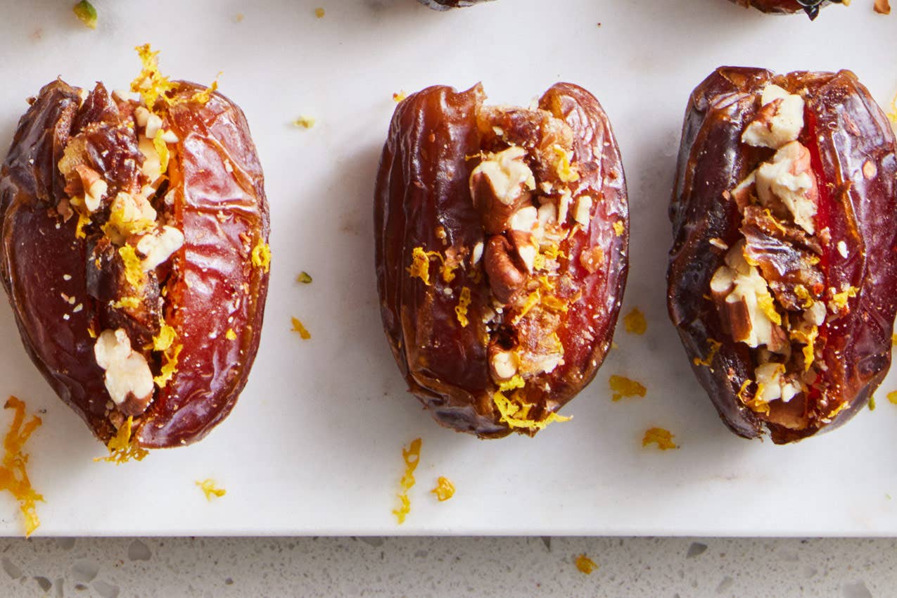 three Medjool dates cut open and stuffed with toasted pecans, orange zest, and Aleppo pepper
