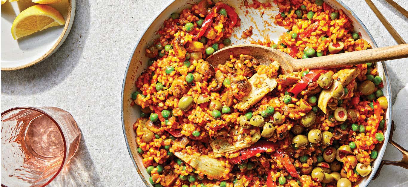 Easy Vegan Paella in a skillet with a wooden serving spoon resting in the dish