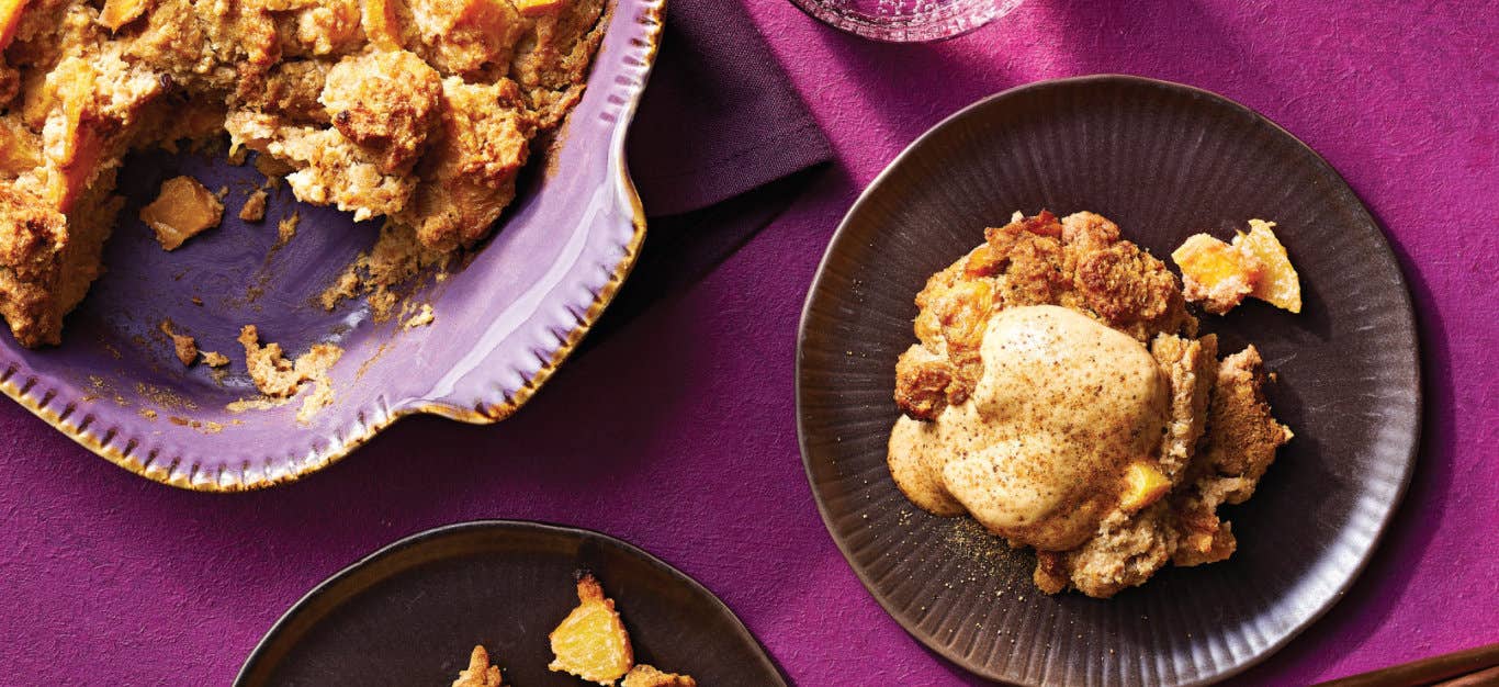 A single serving of Ginger Peach Bread Pudding next to a baking dish against a bright purple tablecloth