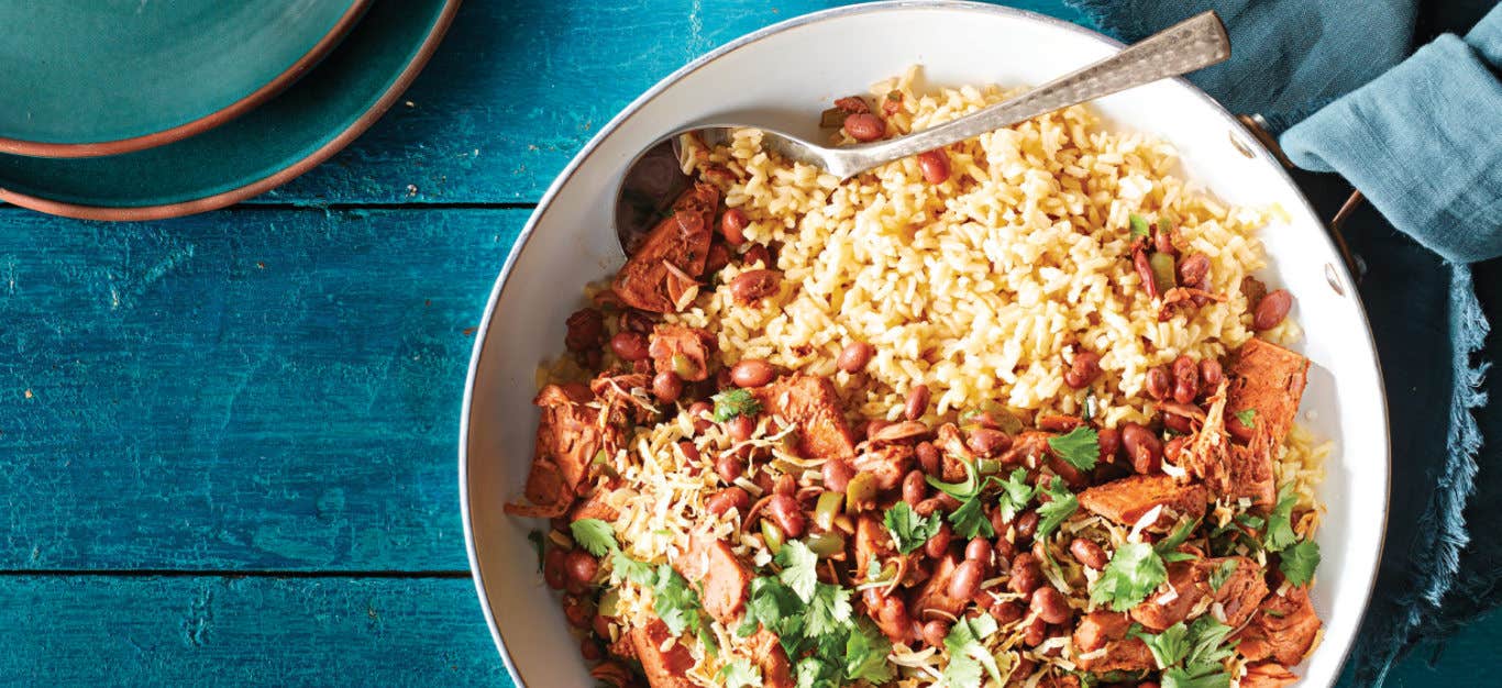 Jerk Jackfruit Skillet with Red Beans in a white bowl on a sea-blue table with a with blue cloth napkin