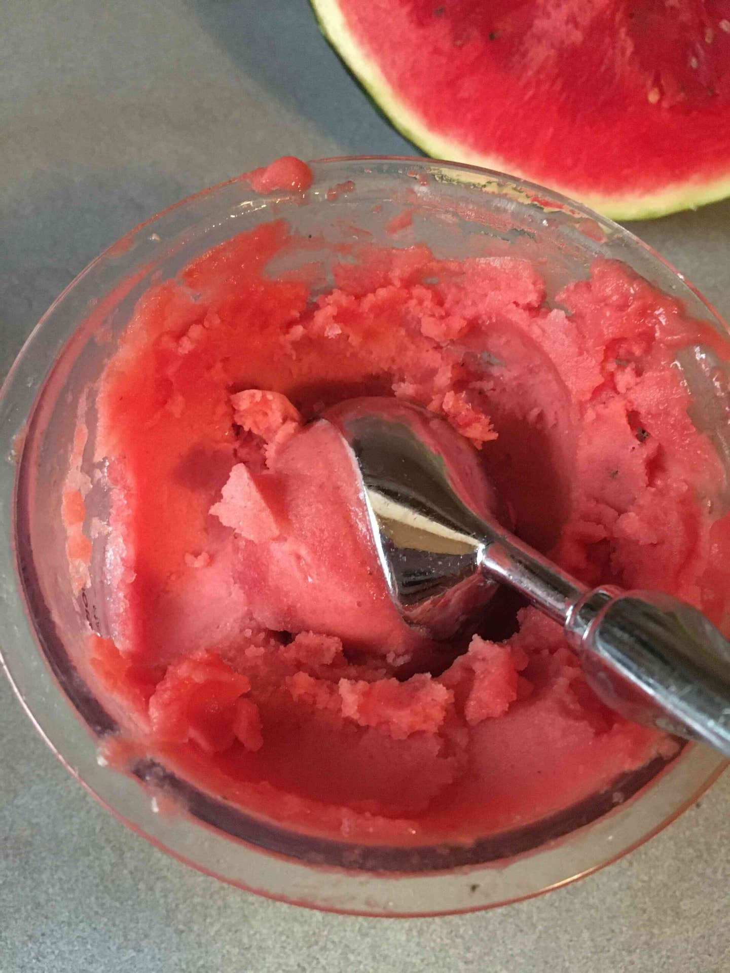 Homemade watermelon sorbet, made using the Ninja Creami. The sorbet is bright red, and there's an ice cream scoop in it