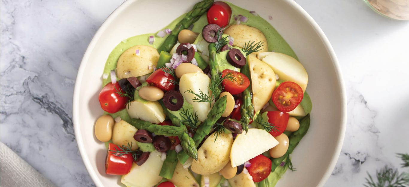 Sarah Cobacho's Creamy Dill Potato Salad in a white bowl on a marble counter