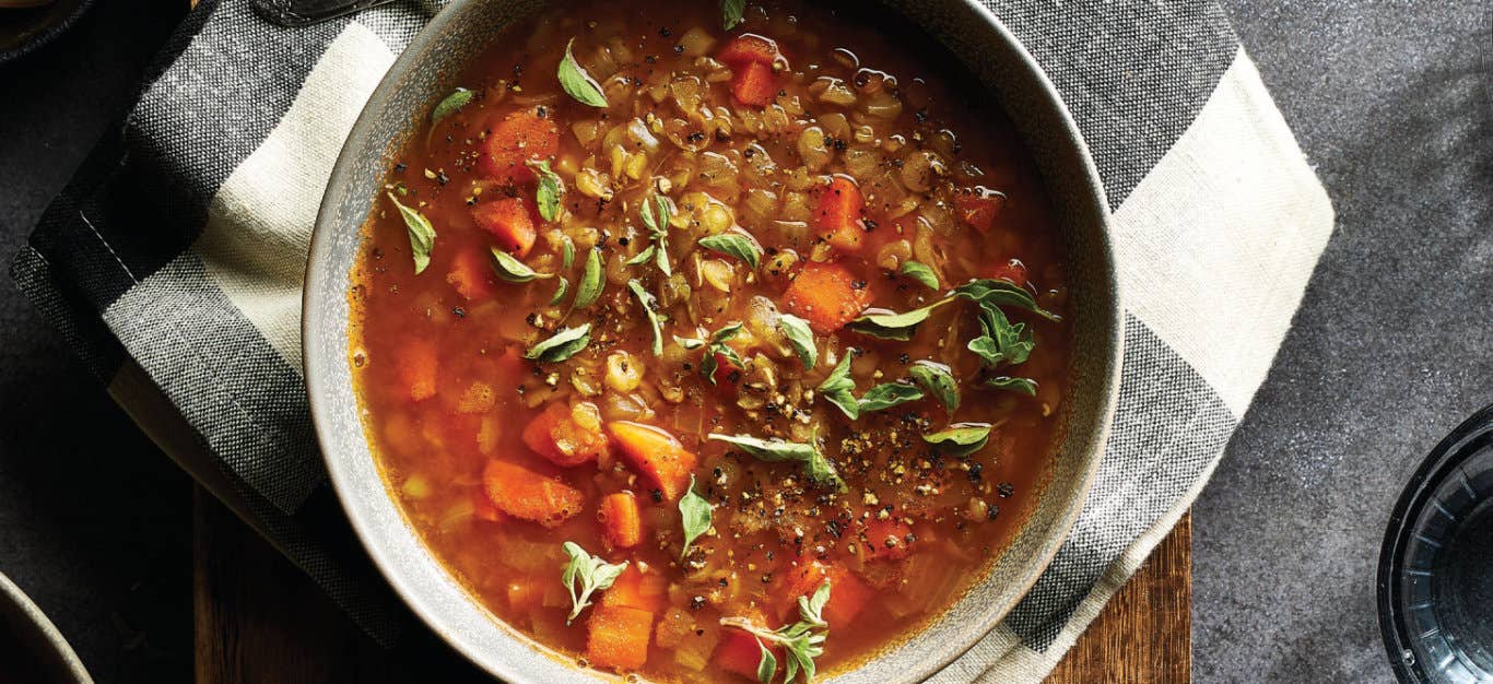 Smoky Vegan Split Pea Soup in a ceramic bowl on a black and white checked cloth napkin