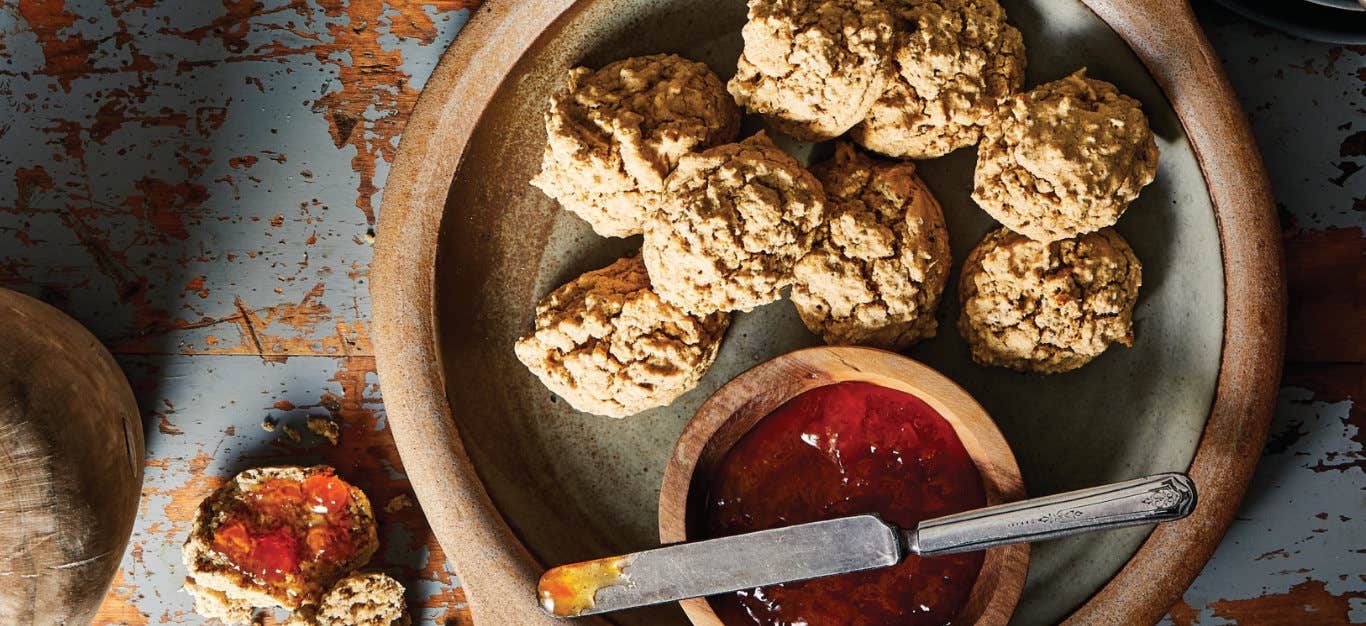 Ann's Short Flax Biscuits on a ceramic plate with a small wooden bowl of jam