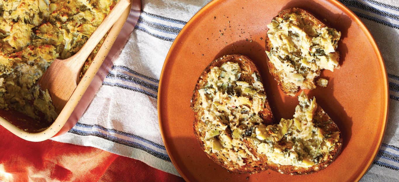 Whole grain toast spread with Baked Kale and Artichoke Dip