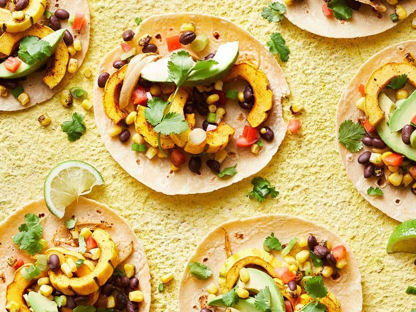 delicata squash tacos with avocado on a yellow surface