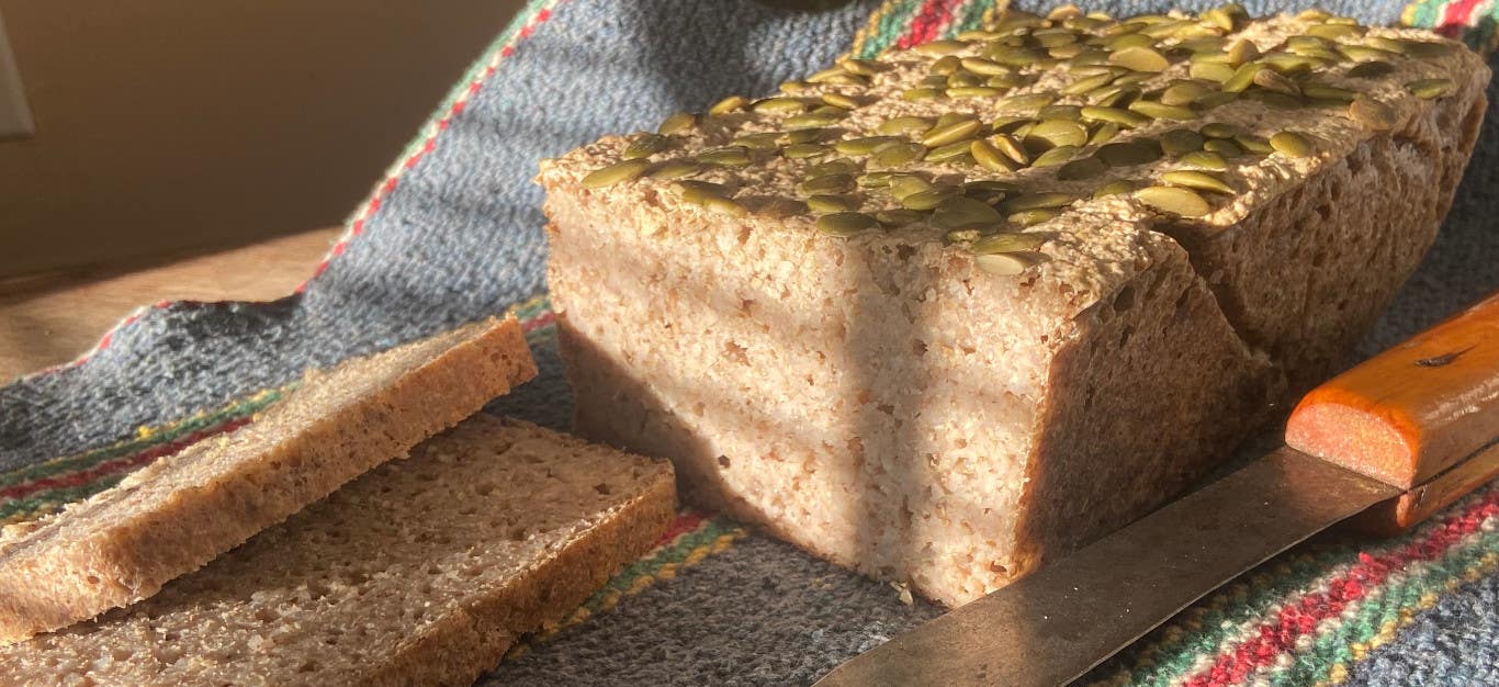 A loaf of buckwheat bread topped with pumpkin seeds