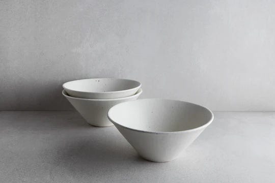 Three deep ceramic stone ramen bowls from the brand Goodies on a gray background