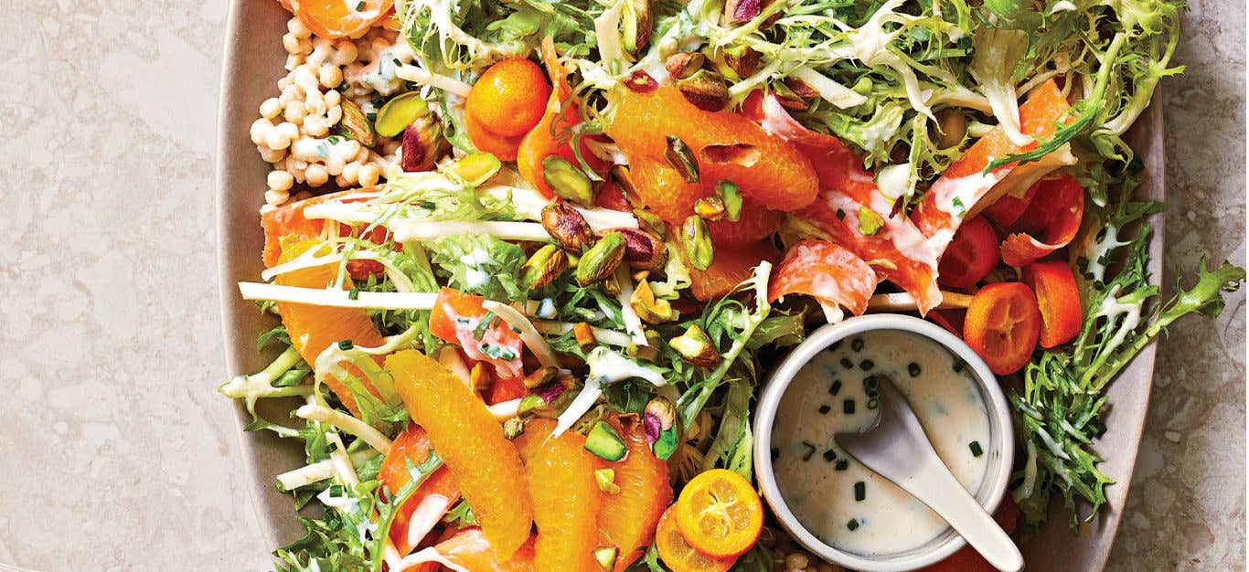 Spicy Citrus Slaw with Pearl Couscous on a large platter with a small bowl of creamy dressing