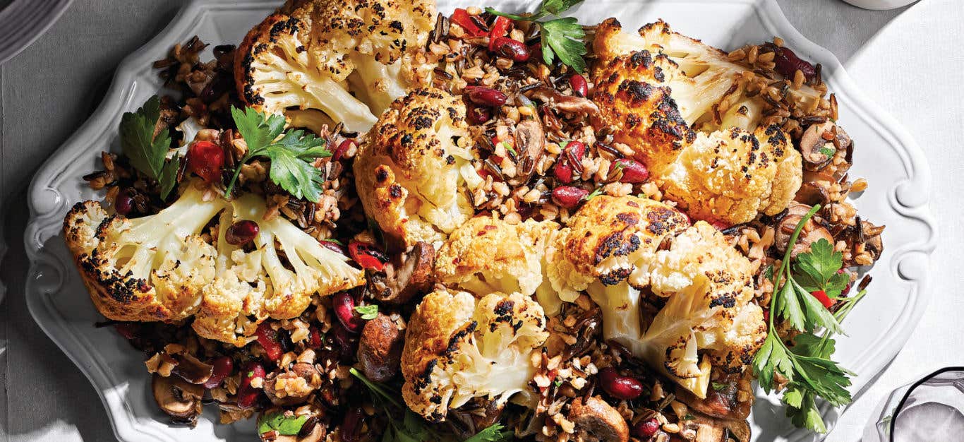 Whole Braised Cauliflower with Mixed-Grain Pilaf on a white serving platter