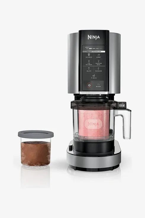 The Ninja creami ice cream maker on a white background with a pint of pink homemade ice cream in it