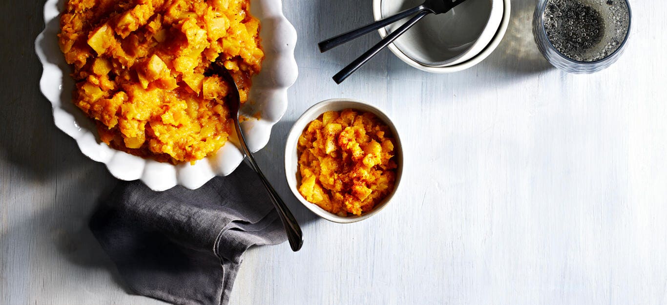 Roasted Red Kuri Squash and Golden Beet Mash in a white serving dish next to a smaller, serving-size dish filled with the mash