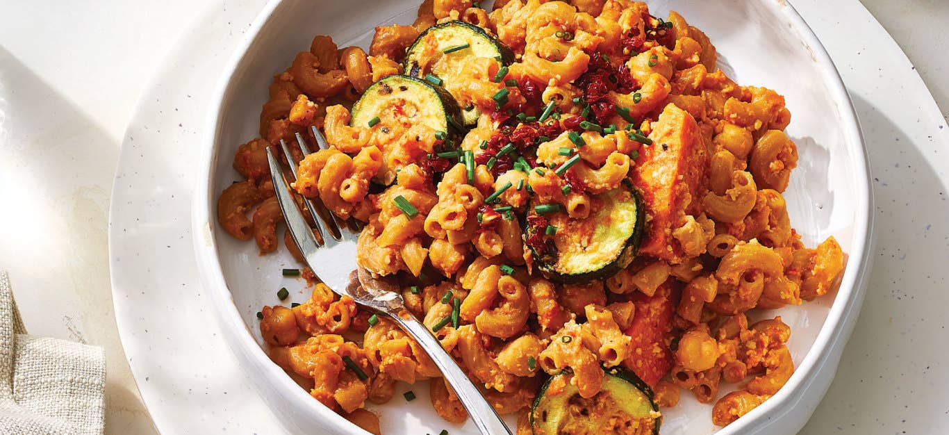 Veggie Mac and Cheese with Sun-Dried Tomatoes in a white bowl resting in a white plate on a white tablecloth