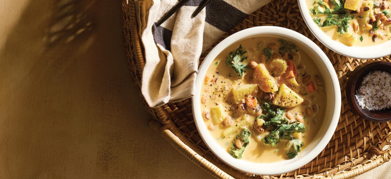 Two white serving bowls of Potato-Kale Black-Eyed Pea Soup