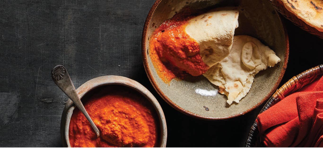 A plate with No-Fry Fryboread dipped in Tomato Pepita Sauce next to a small ceramic bowl of the sauce