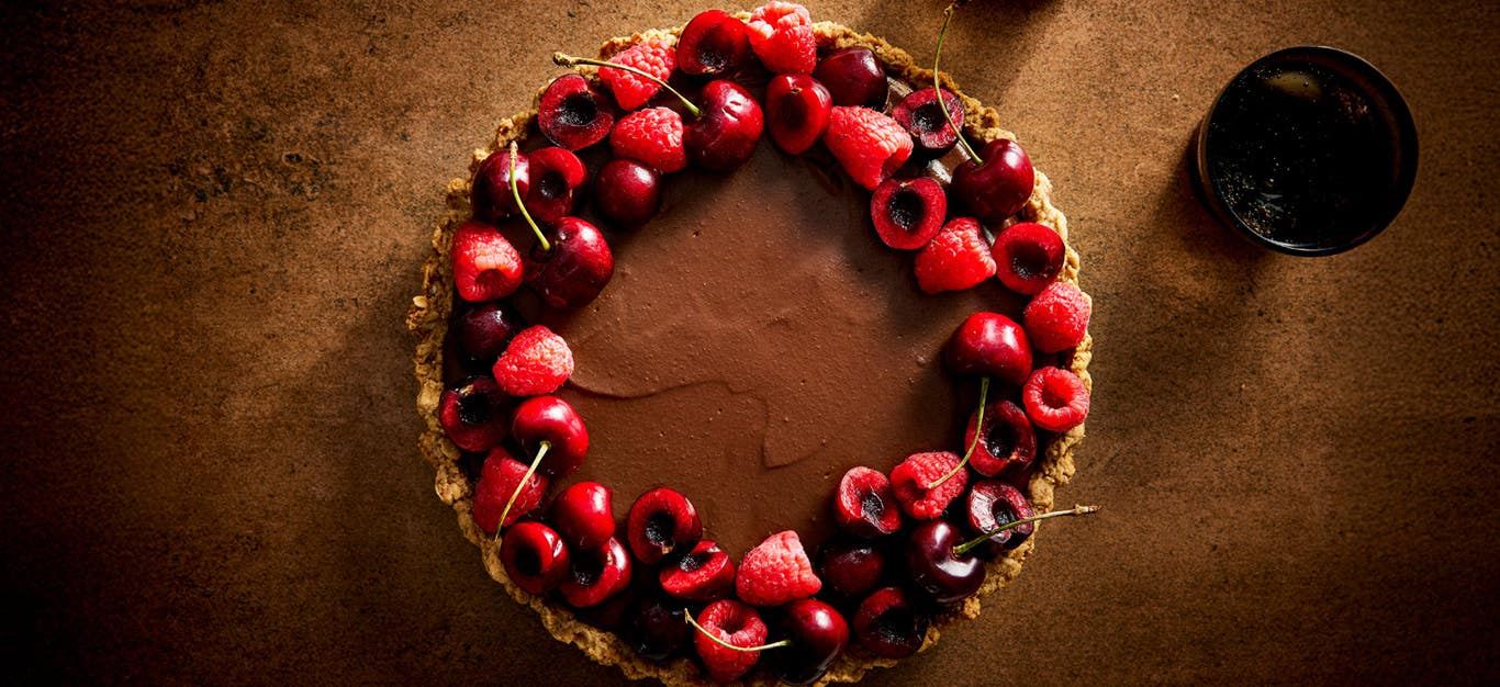 Silky Vegan Chocolate Ganache Tart garnished with fresh cherries and raspberries