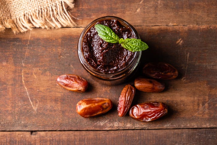 Date paste, a natural homemade sweetener, shown in a jar beside whole dates