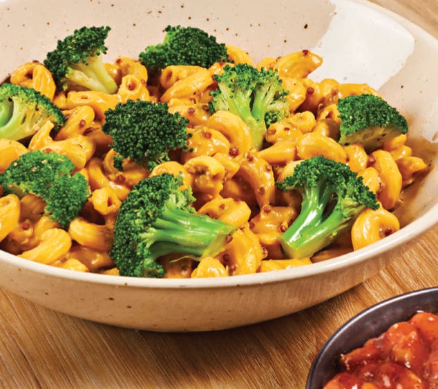 The Southwestern Comfort Mac from Whole Harvest WFPB Meal Delivery Service shown up close in a bowl, featuring a vegan cheese sauce and broccoli