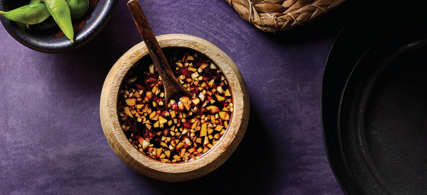 Garlic Dipping Sauce in a rustic brown bowl with a small wooden spoon resting in the bowl