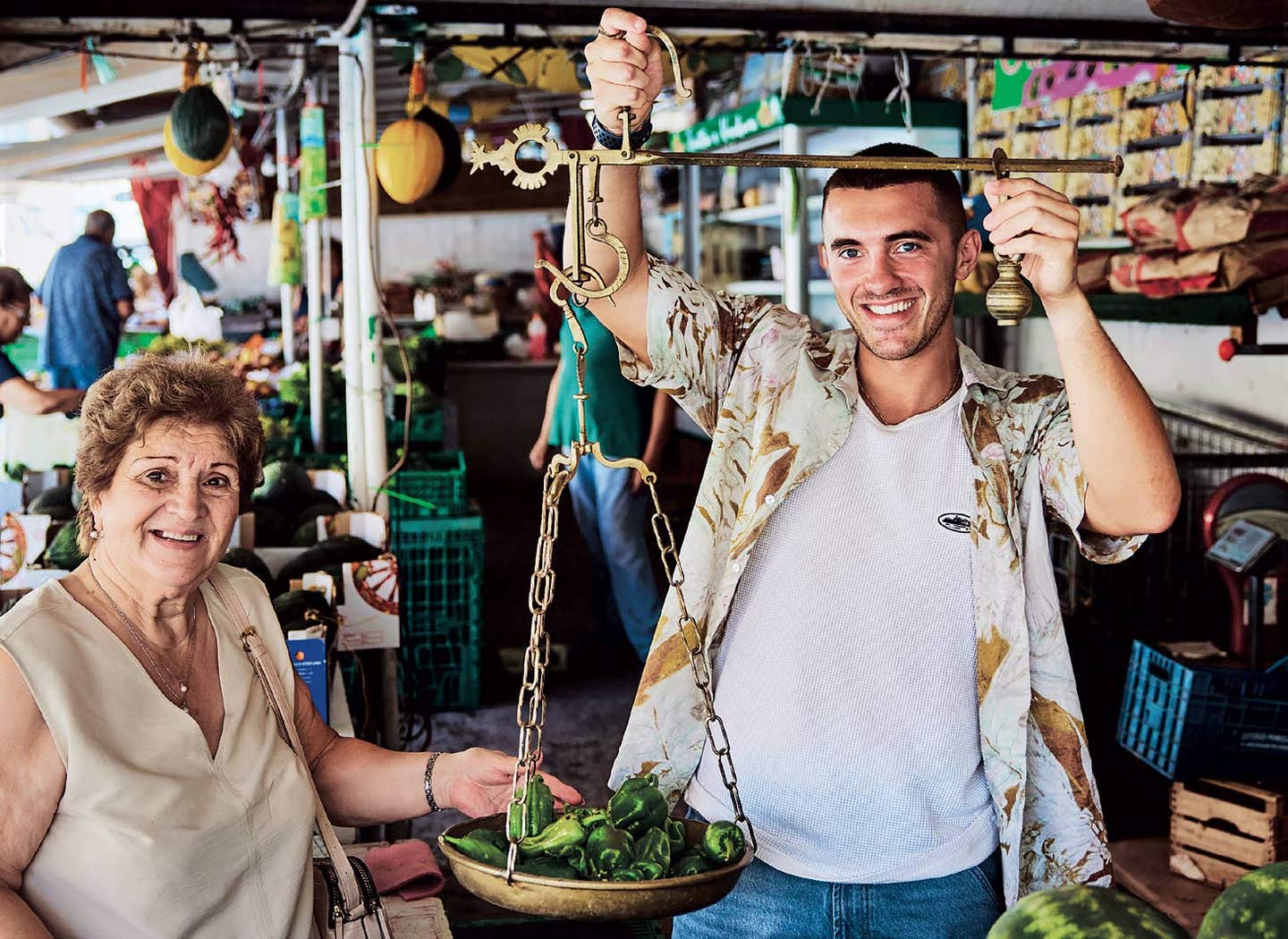 Giuseppe Federici, right, and his grandmother, aka nonna, Marianna, weigh produce at a fresh market on a sunny day