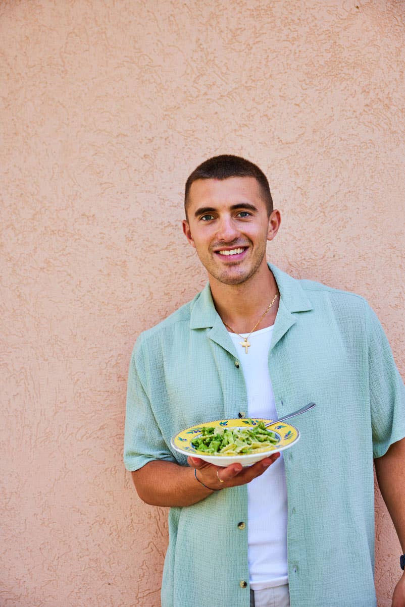 Headshot of Giuseppe Federici holding a plate of vegan pasta