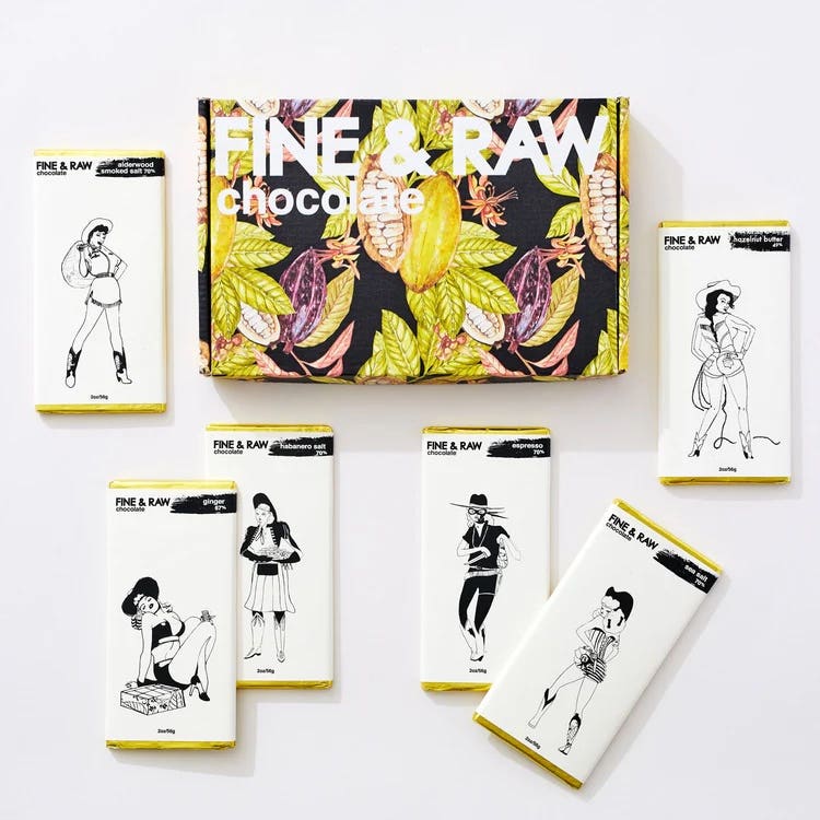 An array of vegan chocolate bars by Fine &amp; Raw, next to a floral gift box that they come in