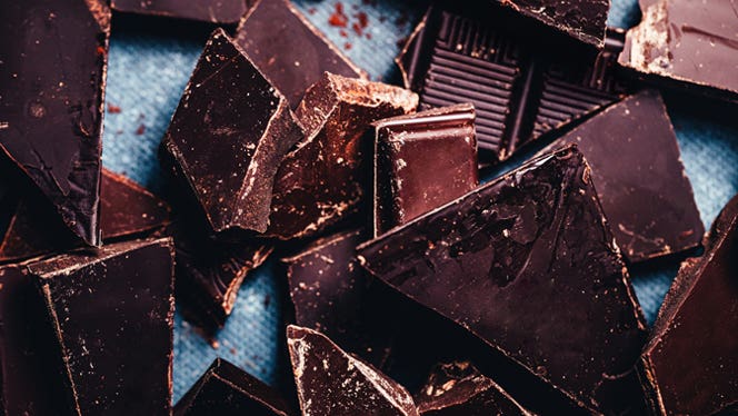 Close up of dark vegan chocolate bar broken into pieces