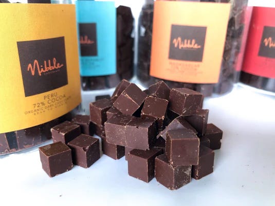 Vegan chocolate cubes next to jars by Nibble