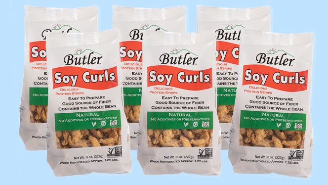 Six bags of Butler Soy Curls on a blue background