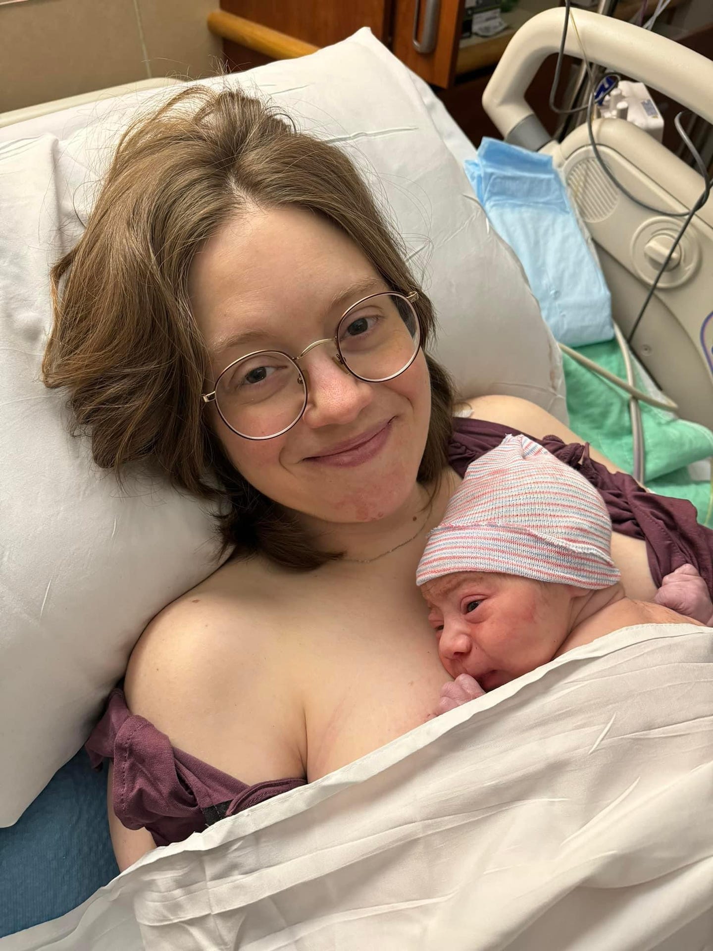 New plant-based mom Brittany Jaroudi smiles as she holds her newborn son in the hospital room