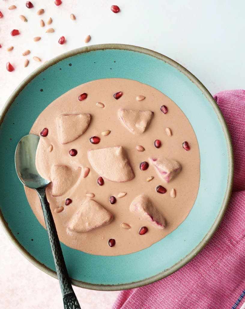 Dora Ramírez's pink mole in a blue bowl, garnished with pomegranate seeds, from Ramírez's vegan Mexican cookbook Comida Casera